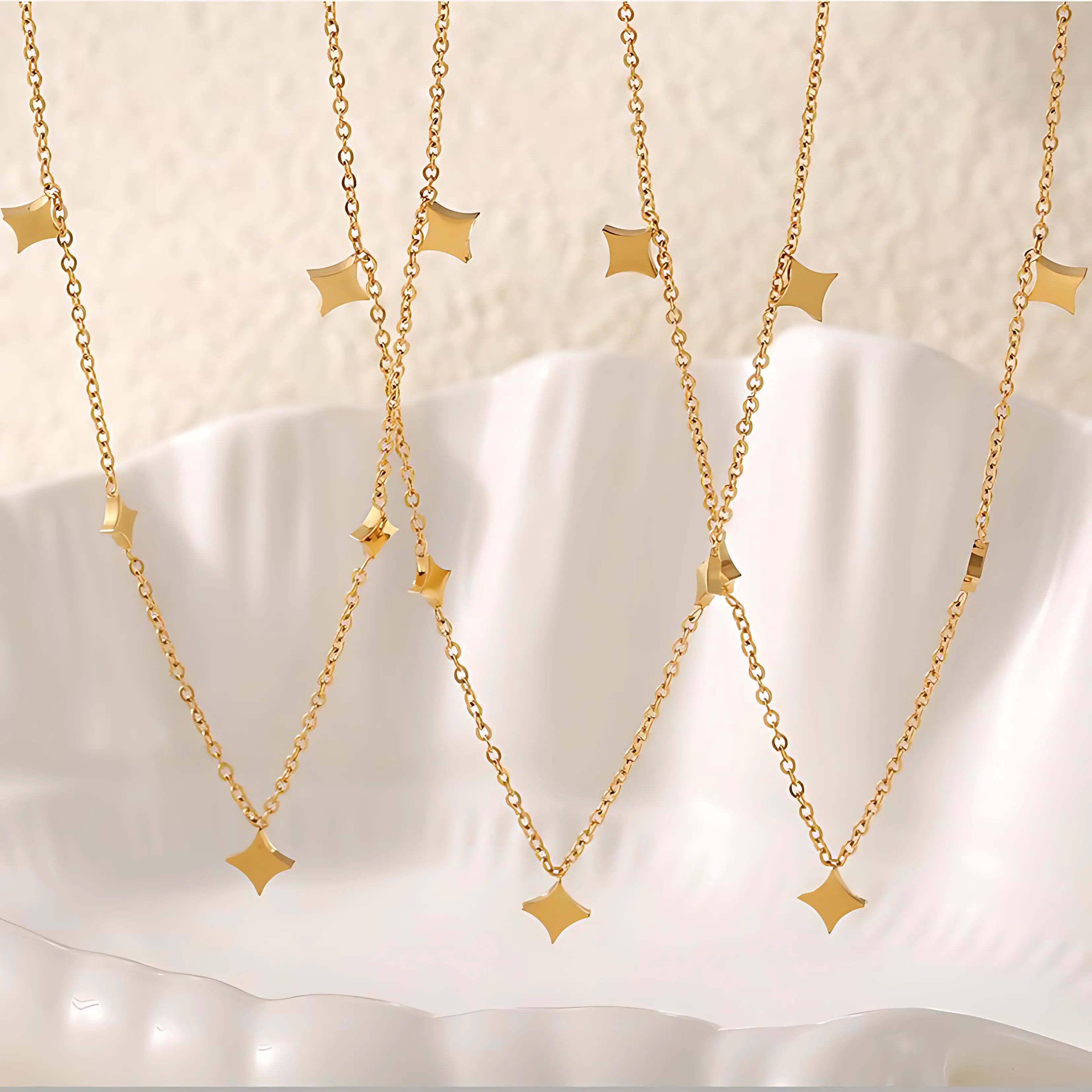 Multiple gold star charm necklaces hanging elegantly, showcasing their delicate chain and charm details.