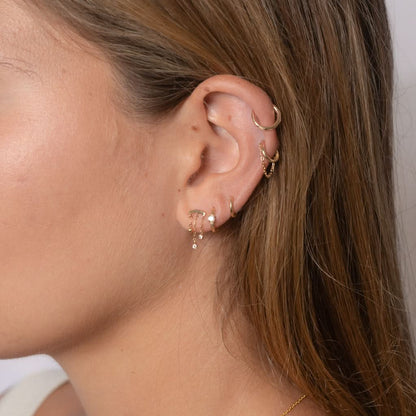 Our versatile chain and CZ ear cuff can be dressed up or down to suit any occasion. Whether you're going for a casual or a more formal look, this earring is the perfect finishing touch