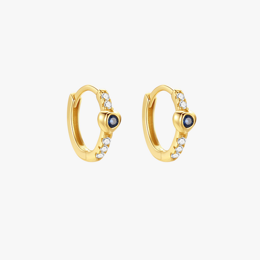 Elegant 14k gold huggie hoop earrings featuring a vibrant blue gemstone center and sparkling cubic zirconia accents, perfect for adding a luxurious touch to any outfit.