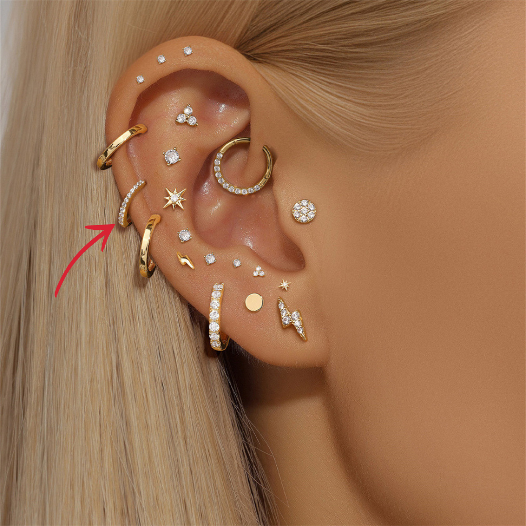 A beautifully stacked ear featuring 14K gold cubic zirconia huggie earrings, ideal for curated ear looks.