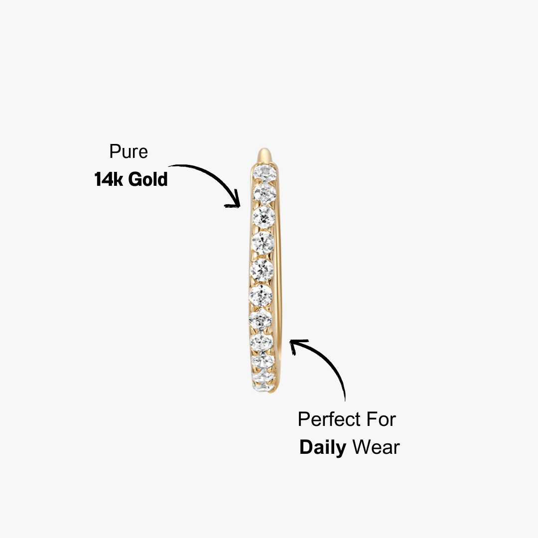 Close-up front view of a 14K gold cubic zirconia huggie earring, showcasing its sparkling stone details.