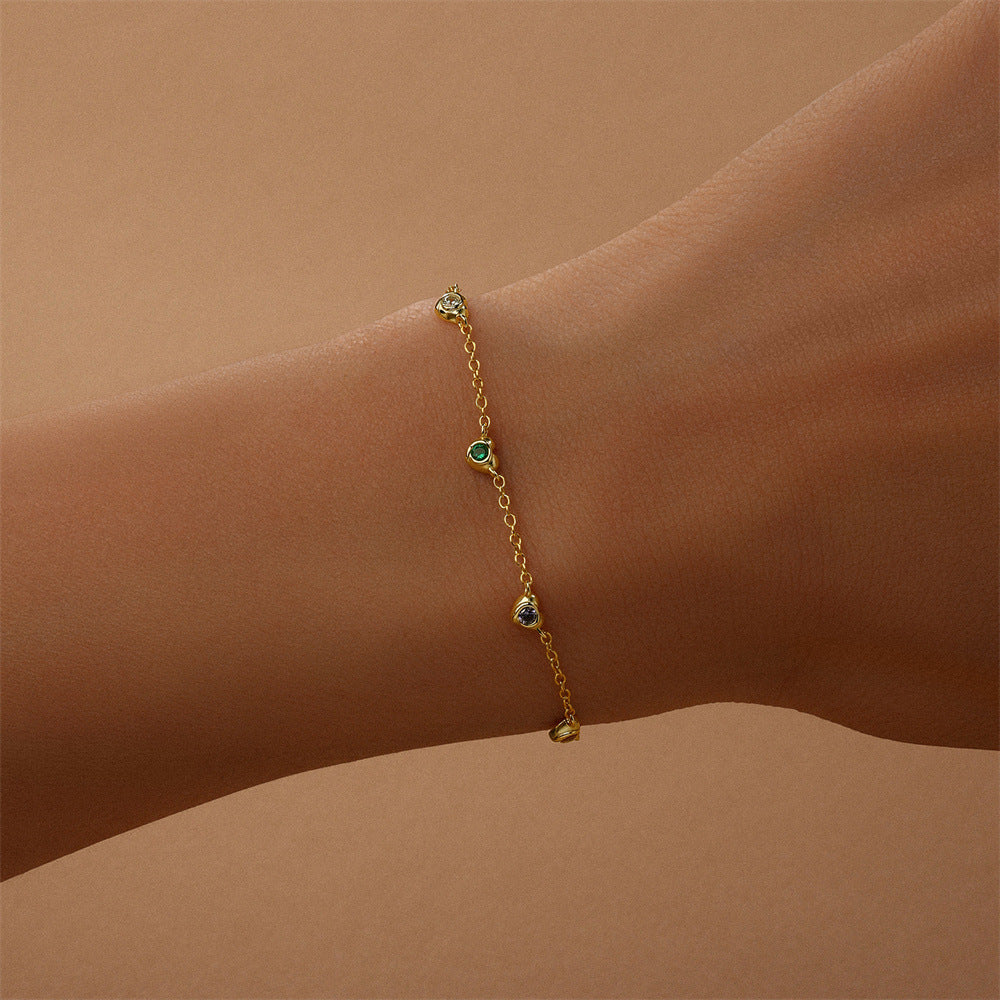 14k-gold-multicolor-bracelet-on-wrist.png – Dainty 14k gold bracelet adorned with colorful gemstones, shown on a wrist to highlight its delicate, everyday wear appeal.