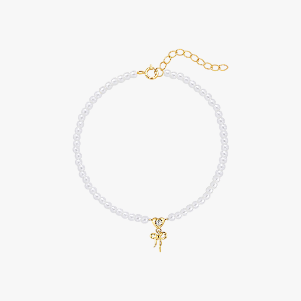 14k-gold-pearl-bracelet-bow-charm-main.png – Elegant pearl bracelet with a 14k gold bow charm, featuring adjustable chain closure for a classic and feminine touch.