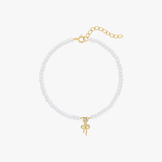 14k-gold-pearl-bracelet-bow-charm-main.png – Elegant pearl bracelet with a 14k gold bow charm, featuring adjustable chain closure for a classic and feminine touch.