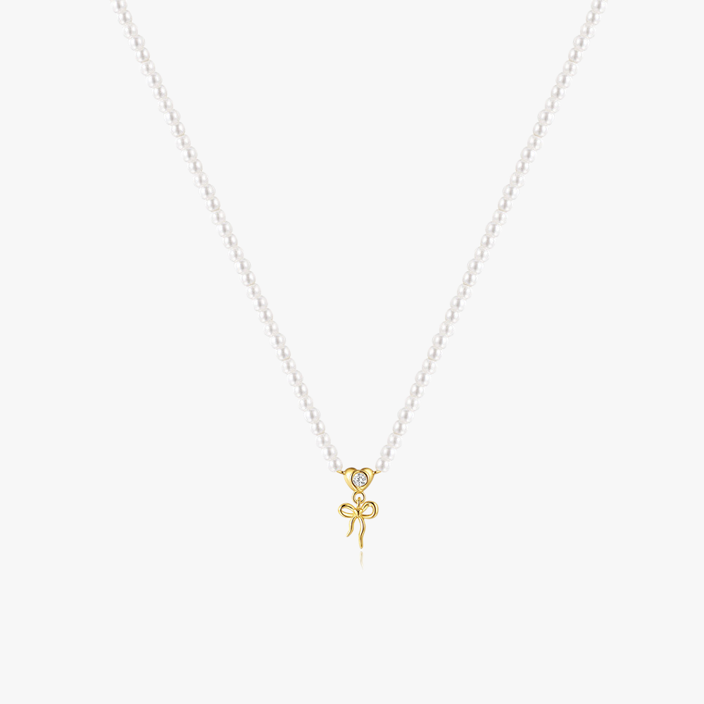 14k-gold-pearl-necklace-bow-charm-main.png – Classic pearl necklace featuring a 14k gold bow charm, designed for a timeless and elegant look.