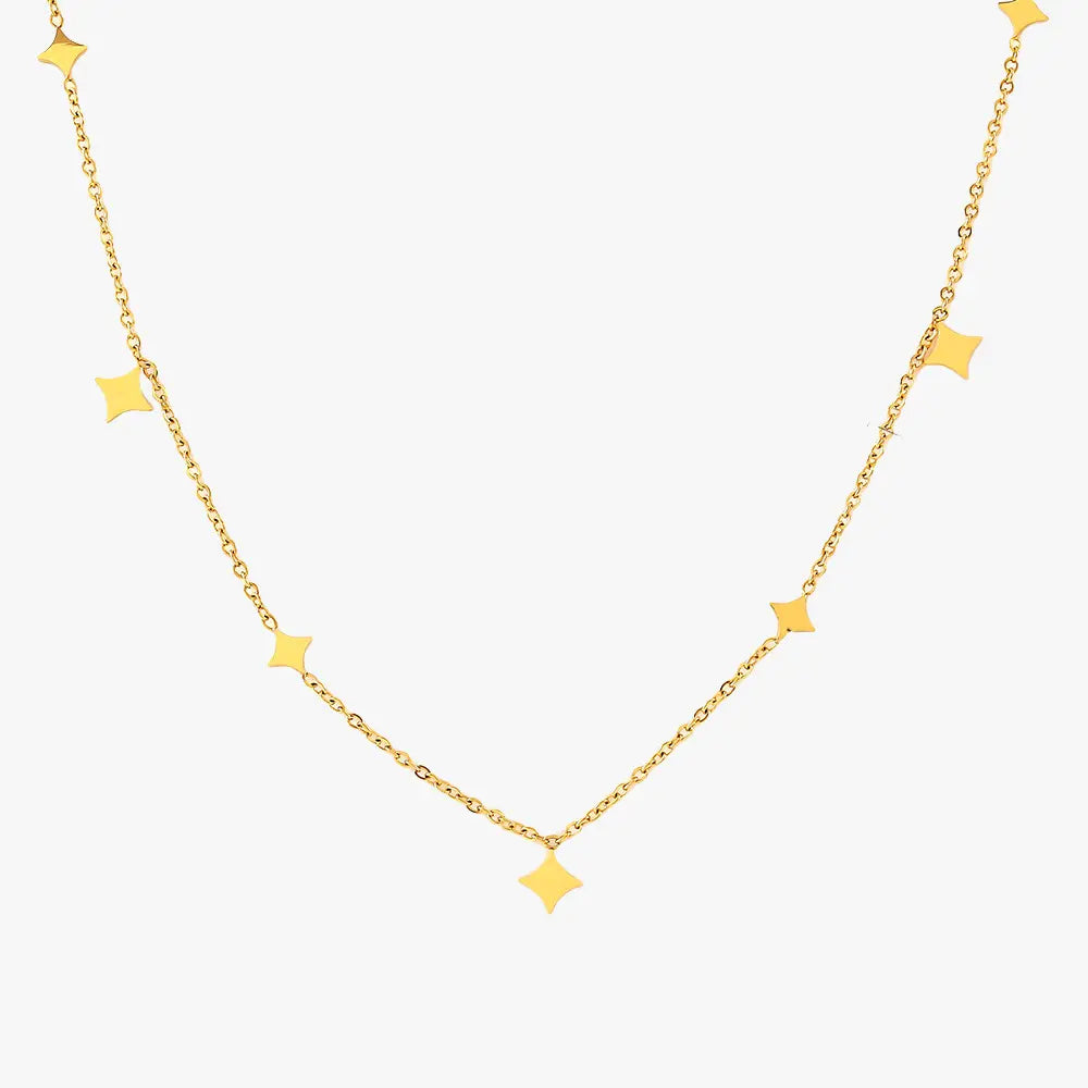 Minimalist gold star charm necklace isolated on a white background.