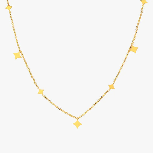 Minimalist gold star charm necklace isolated on a white background.