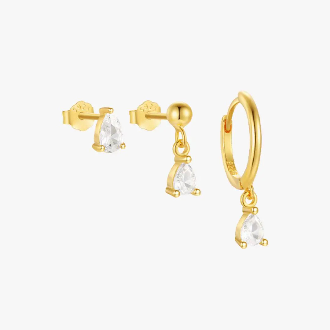 Set of three gold-plated earrings with teardrop-shaped cubic zirconia stones, including a stud, dangling charm, and hoop earring.