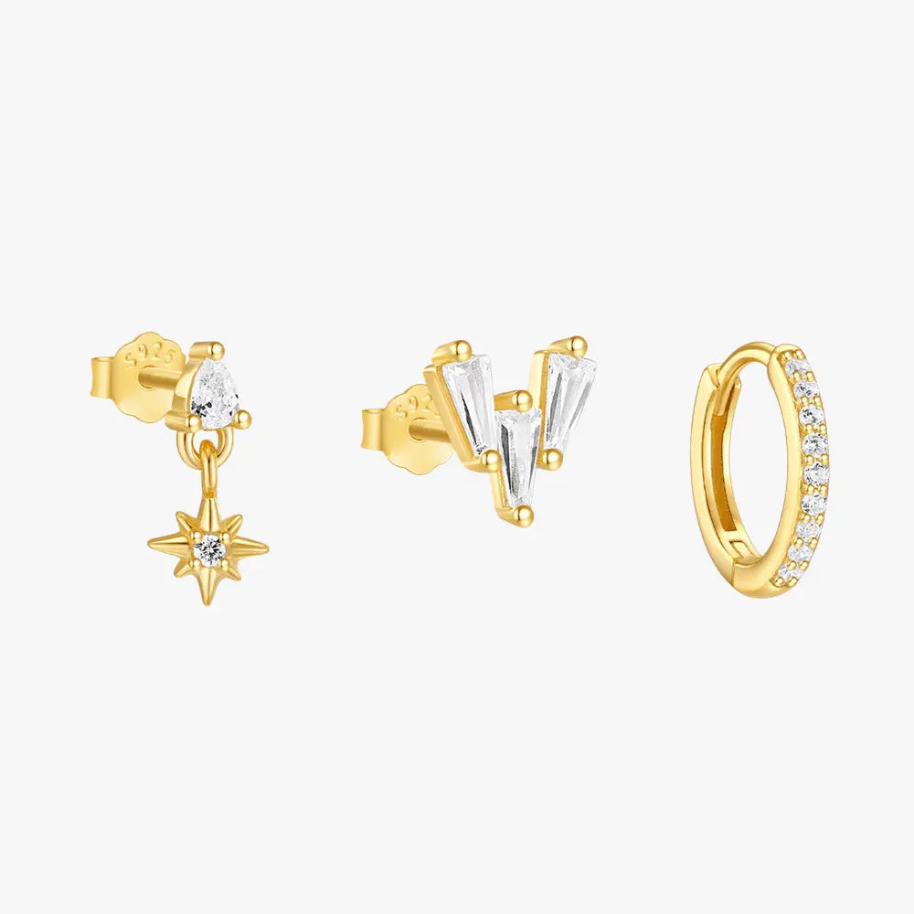 A set of three gold-plated earrings with cubic zirconia details. The first features a pear-shaped crystal with a dangling star charm, the second has a trio of baguette-cut stones arranged in a "V" shape, and the third is a classic gold hoop adorned with small crystals.