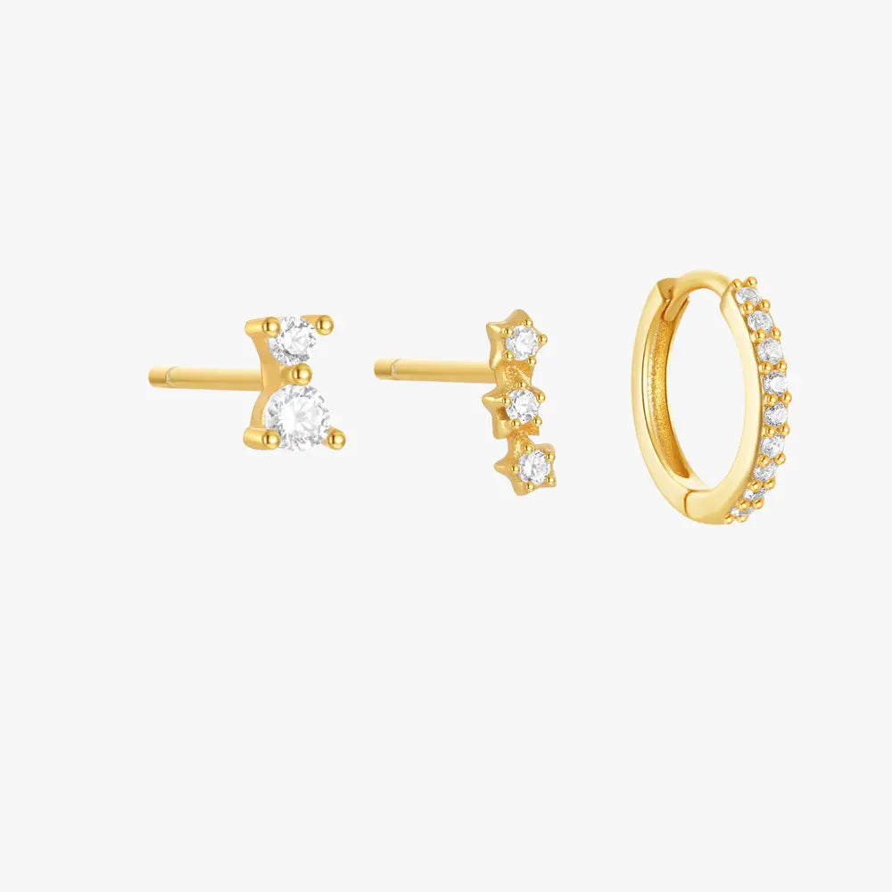 Set of three gold earrings with cubic zirconia accents: one minimalist stud, one star-studded row, and a pave hoop earring.