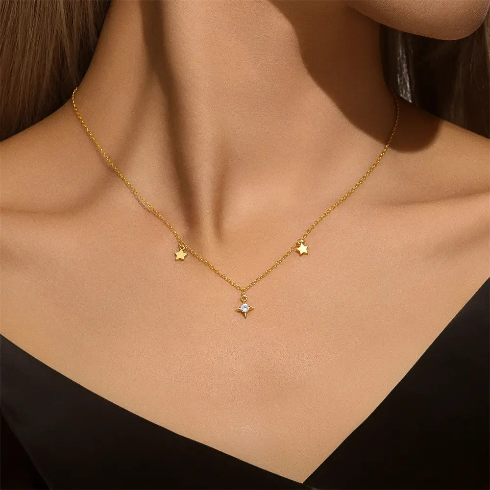 Elegant gold necklace with star and diamond-shaped pendants, crafted from 925 sterling silver, displayed on a white background.