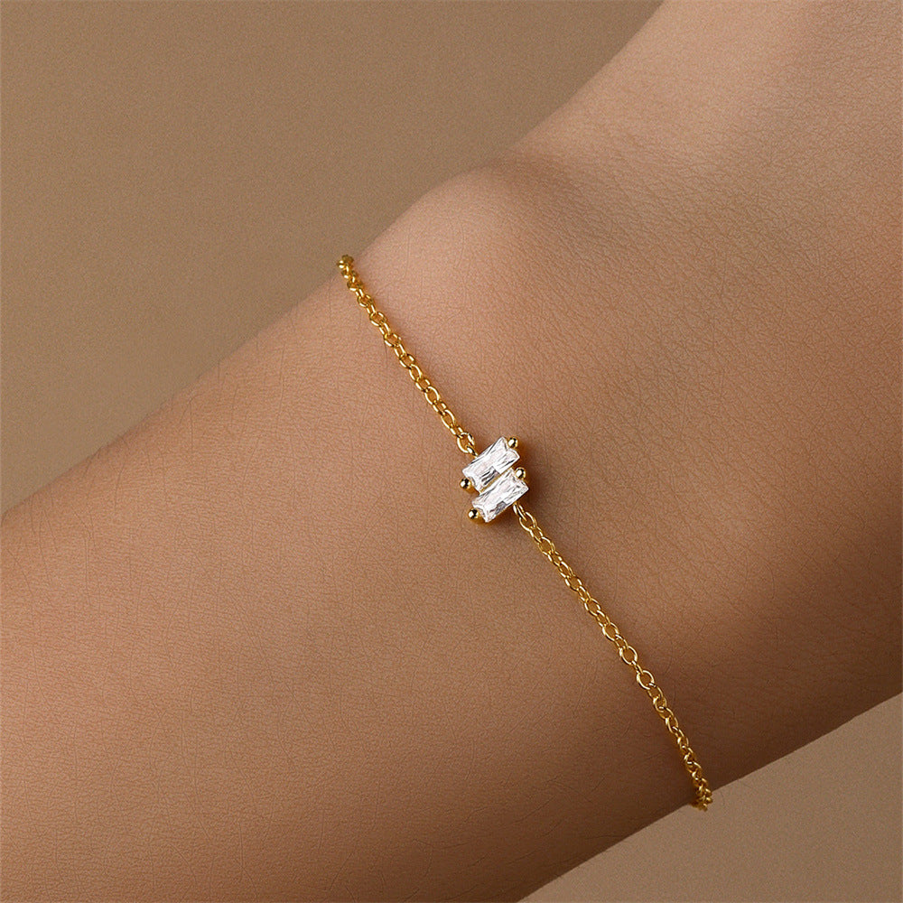 Gold-plated bracelet with baguette-cut zirconia accents, shown on wrist for a stylish and minimalistic look.