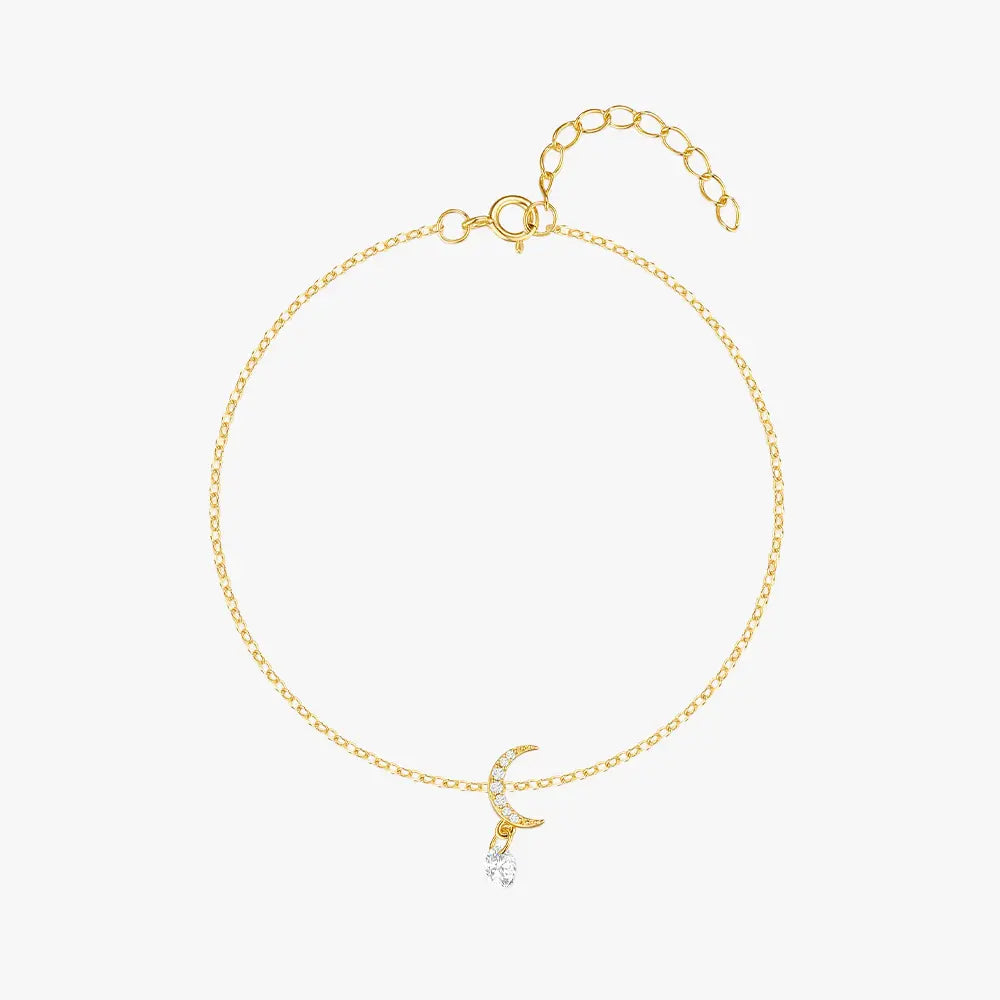 Delicate gold bracelet featuring a crescent moon charm adorned with cubic zirconia and a dangling crystal.