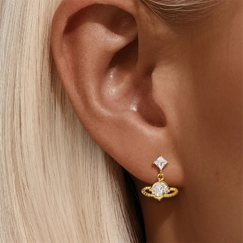 Model wearing 925 sterling silver planet zirconia earrings, featuring a unique planet design with sparkling zirconia stones, perfect for elegant looks.