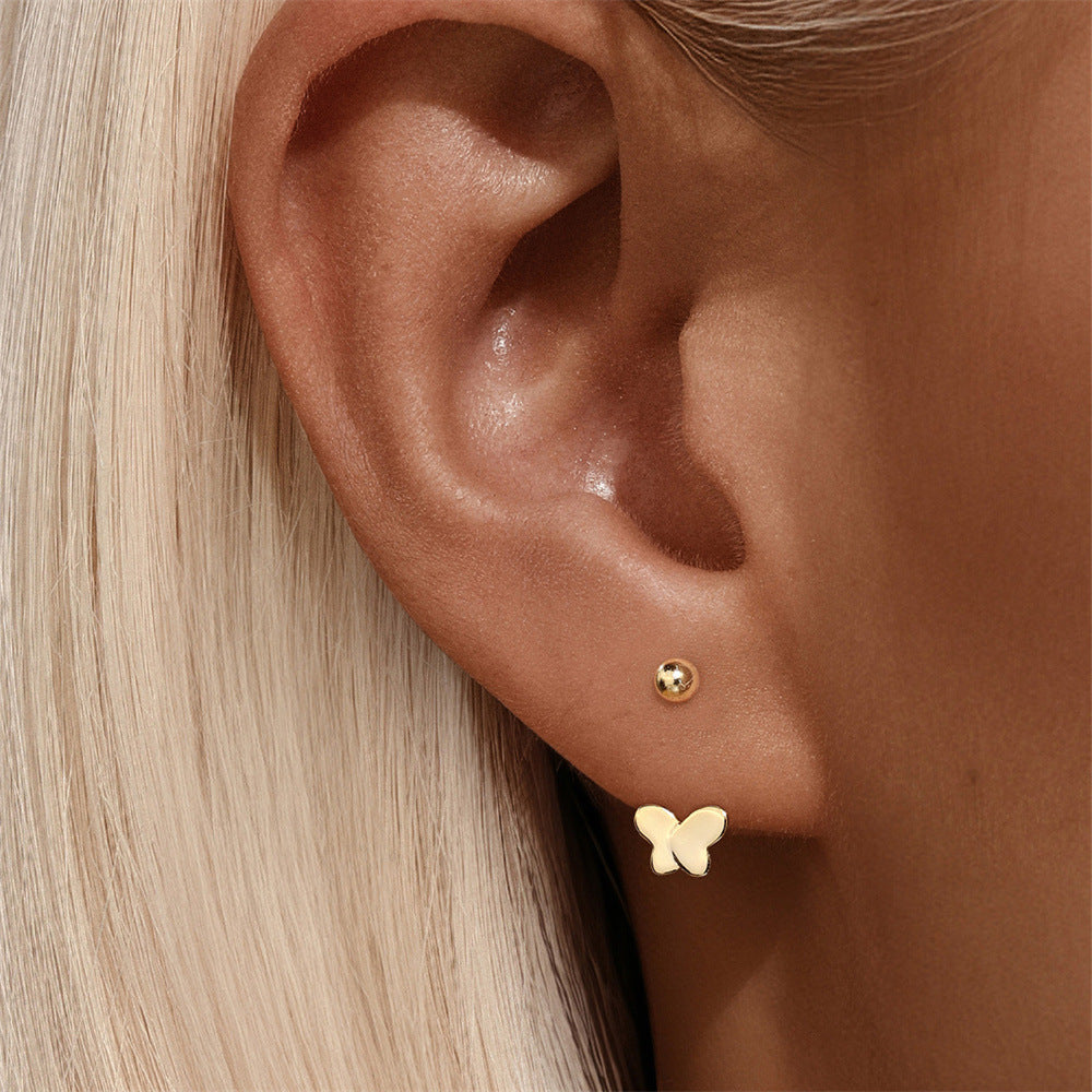 Model wearing elegant gold butterfly earrings made of real 18k gold. Stylish and perfect for adding a touch of sophistication to any look.