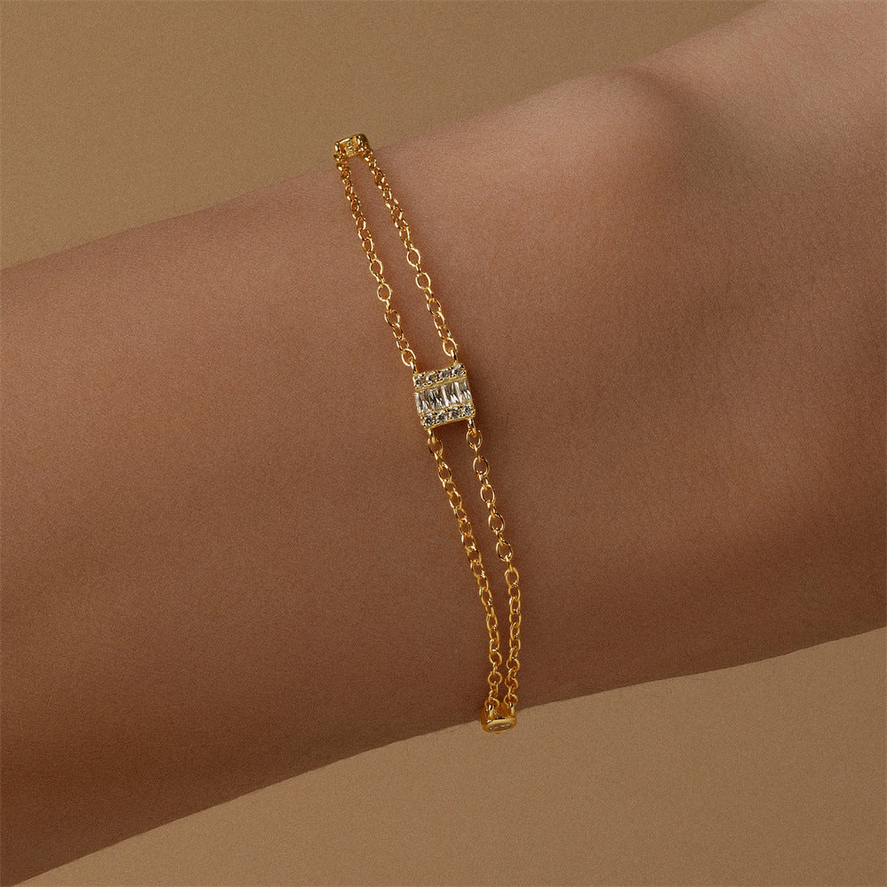 Minimalist gold-plated bracelet featuring cubic zirconia accents, perfect for layering.