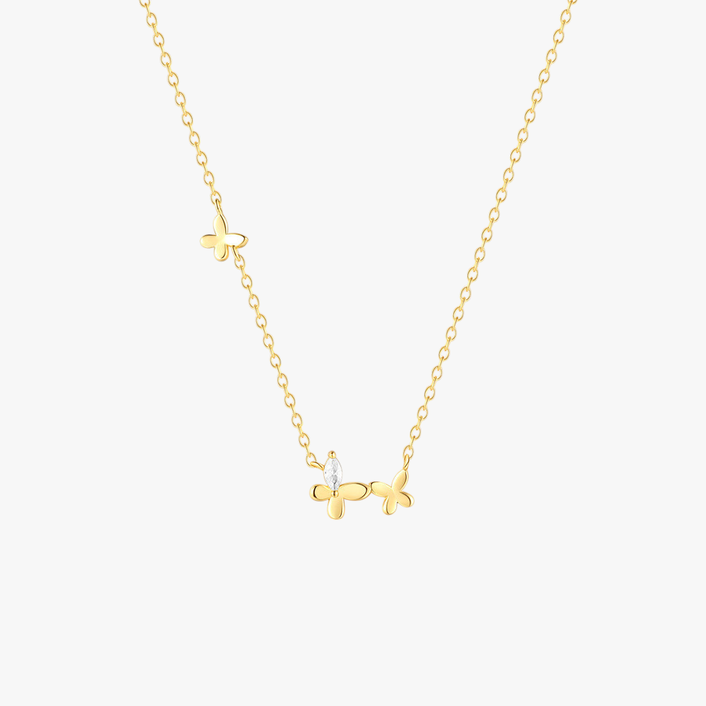 Close-up of a gold butterfly necklace with a zircon accent on a fine chain.