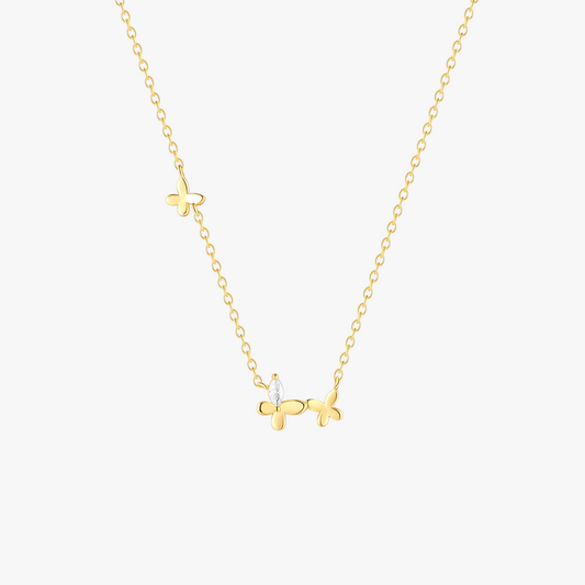 Close-up of a gold butterfly necklace with a zircon accent on a fine chain.