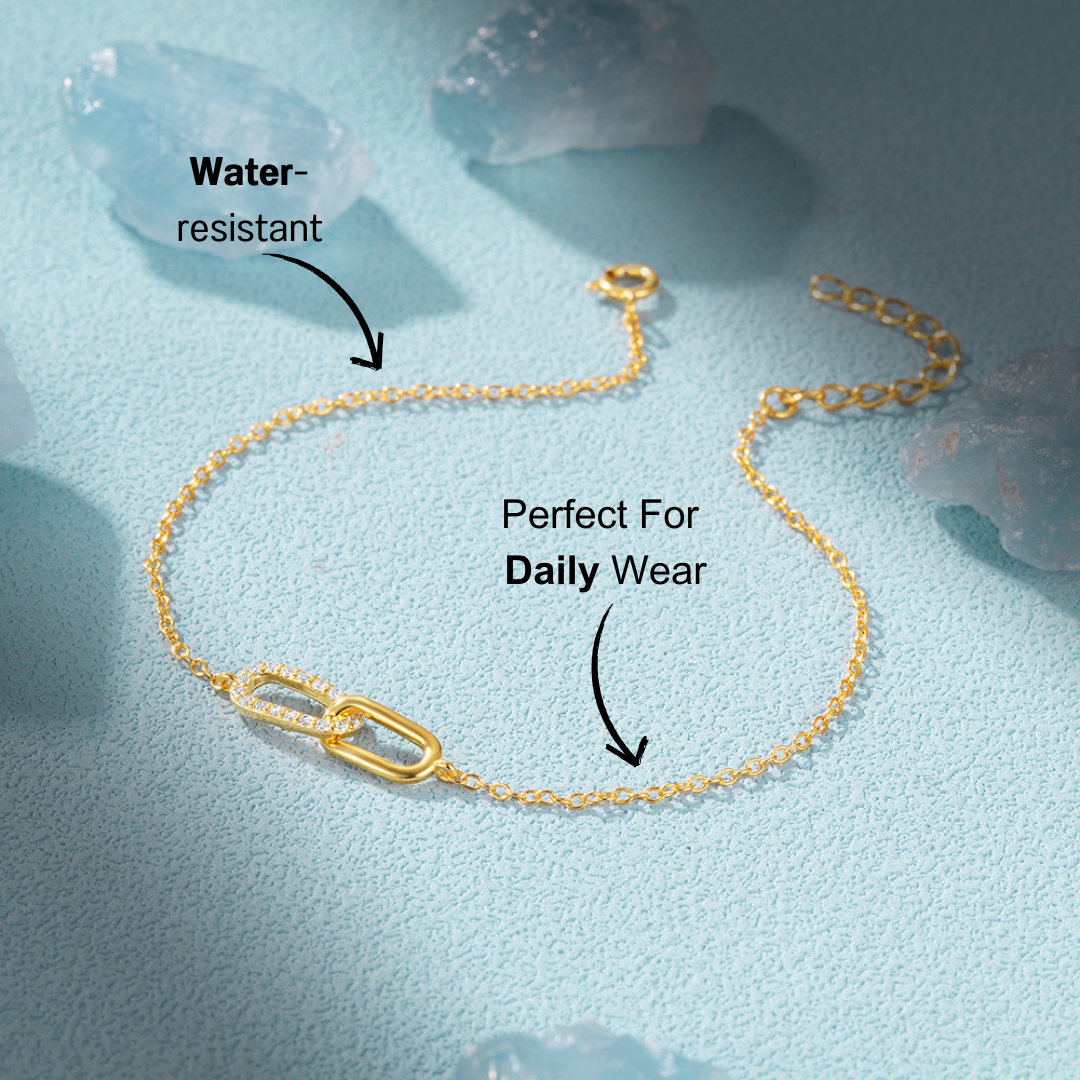 Close-up of the gold crossover zirconia bracelet, highlighted with sparkling zirconia stones.