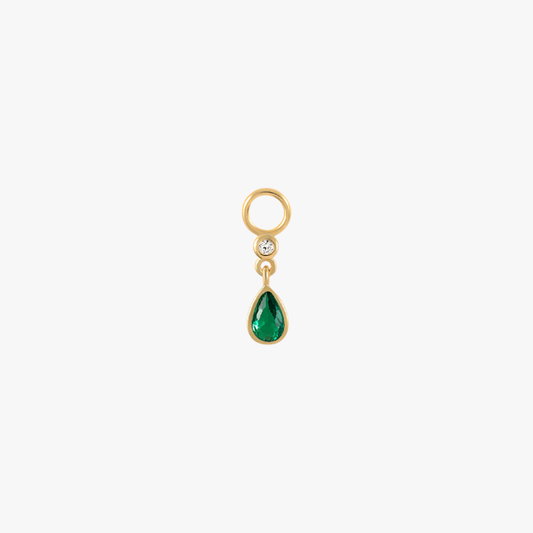 A gold charm with an emerald teardrop.