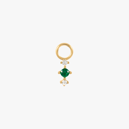 A gold charm with an emerald and diamonds.