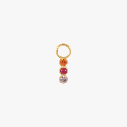 A gold charm with multi-colored gemstones.