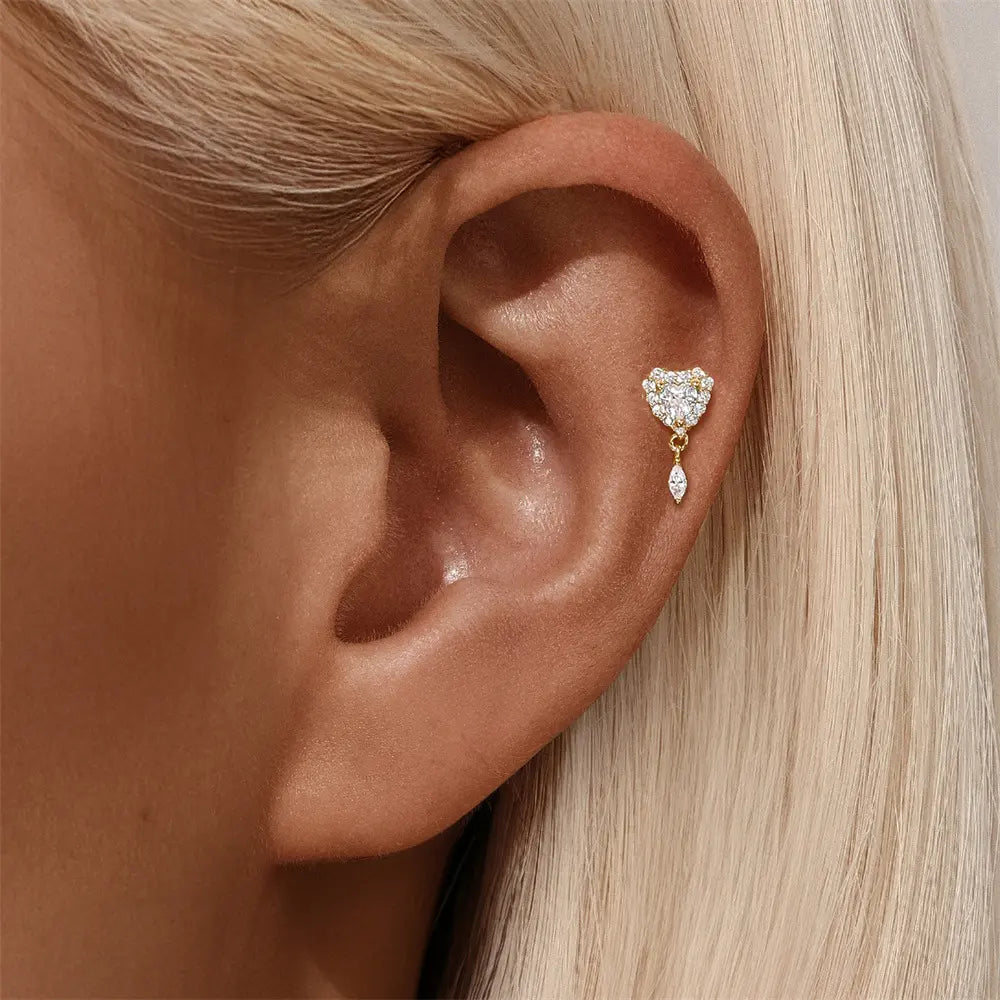 Model wearing a gold-plated heart-shaped stud earring with dangling crystals for an elegant look.