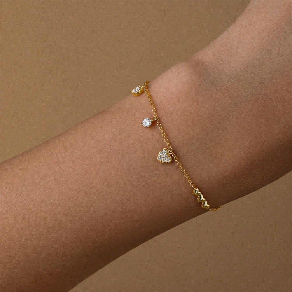 Gold bracelet with heart charm and sparkling zircon stone