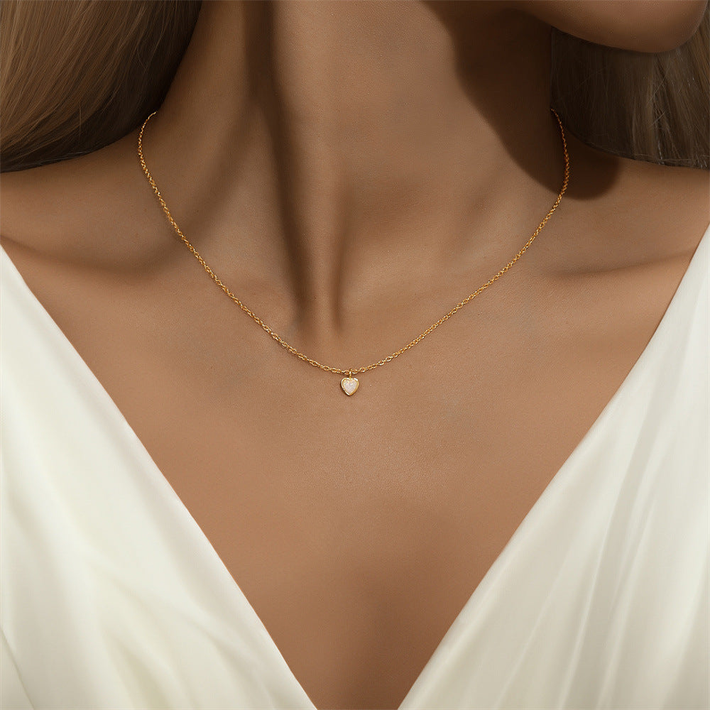 Woman wearing a gold heart-shaped opal necklace