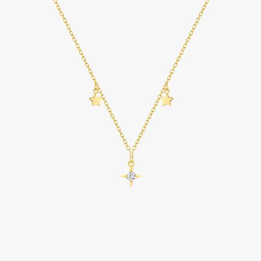 Golden star-themed necklace showcased on a neutral beige background, emphasizing its sophisticated design.