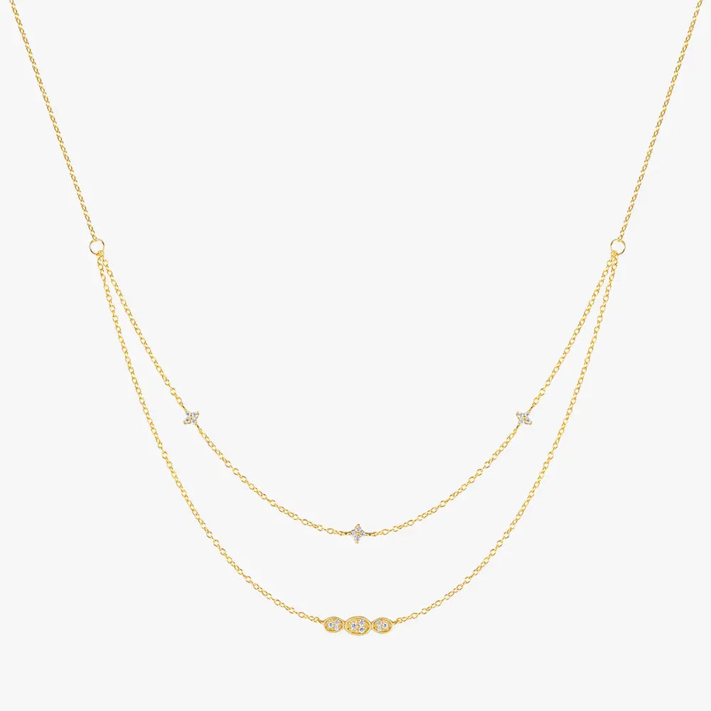 Gold layered necklace with cubic zirconia accents, featuring delicate star motifs and an oval-shaped crystal bar pendant, made from 925 sterling silver.