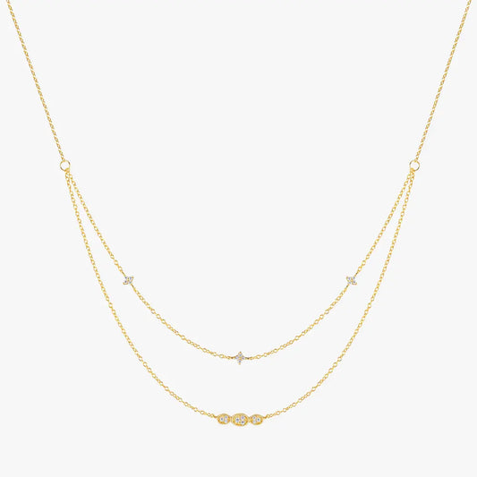 Gold layered necklace with cubic zirconia accents, featuring delicate star motifs and an oval-shaped crystal bar pendant, made from 925 sterling silver.