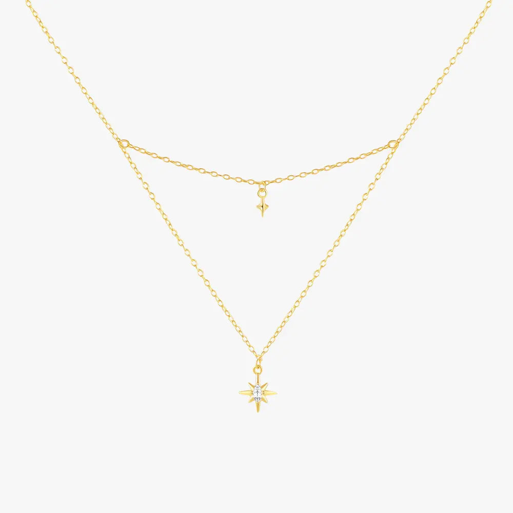 Gold layered necklace with a starburst pendant and a delicate small star charm, crafted in 925 sterling silver with gold plating.