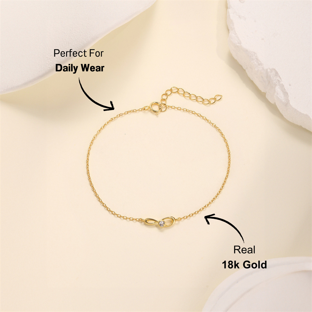 Close-up of S925 gold infinity bracelet with zirconia accent on soft background