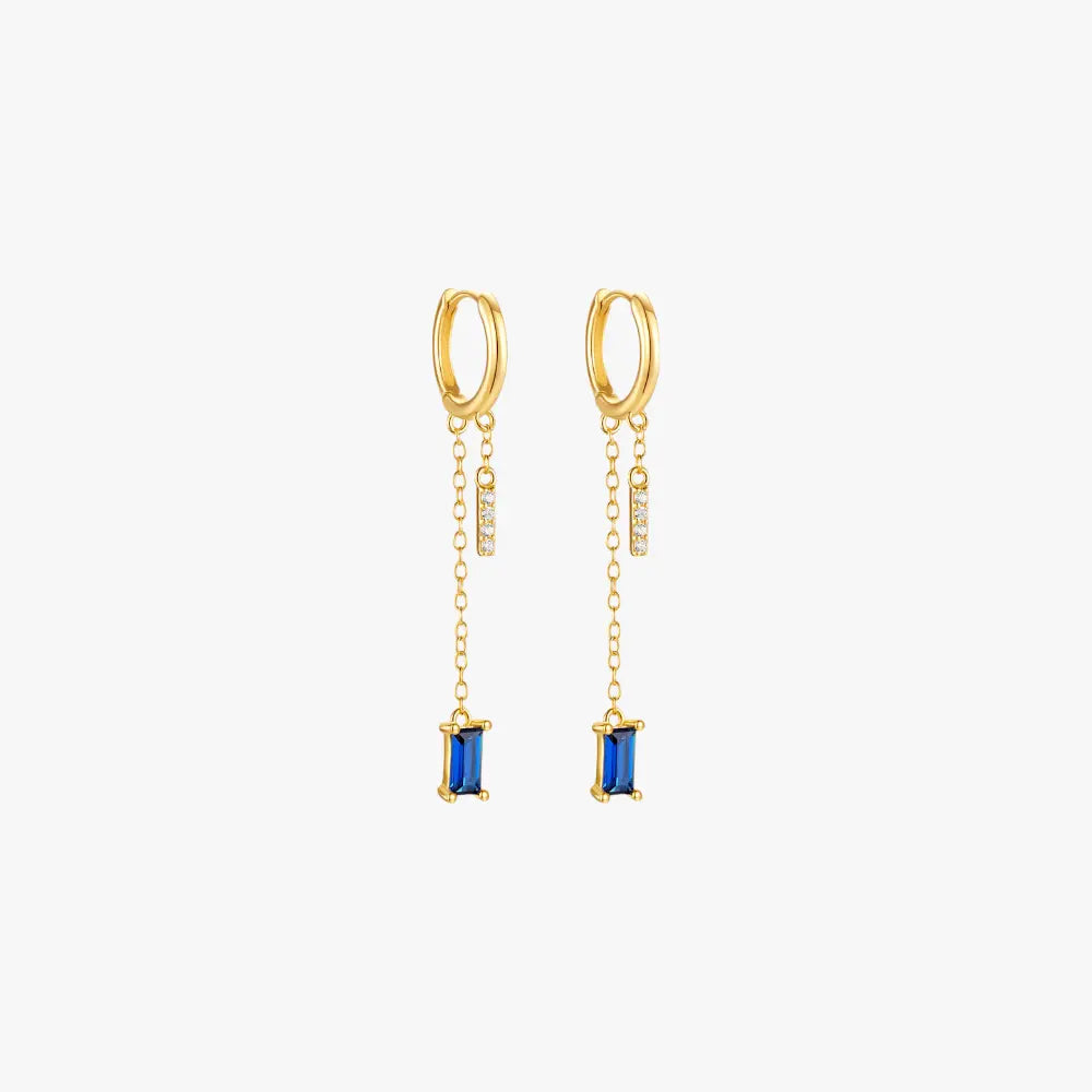 Gold drop earrings with blue gemstones, luxurious and trendy.