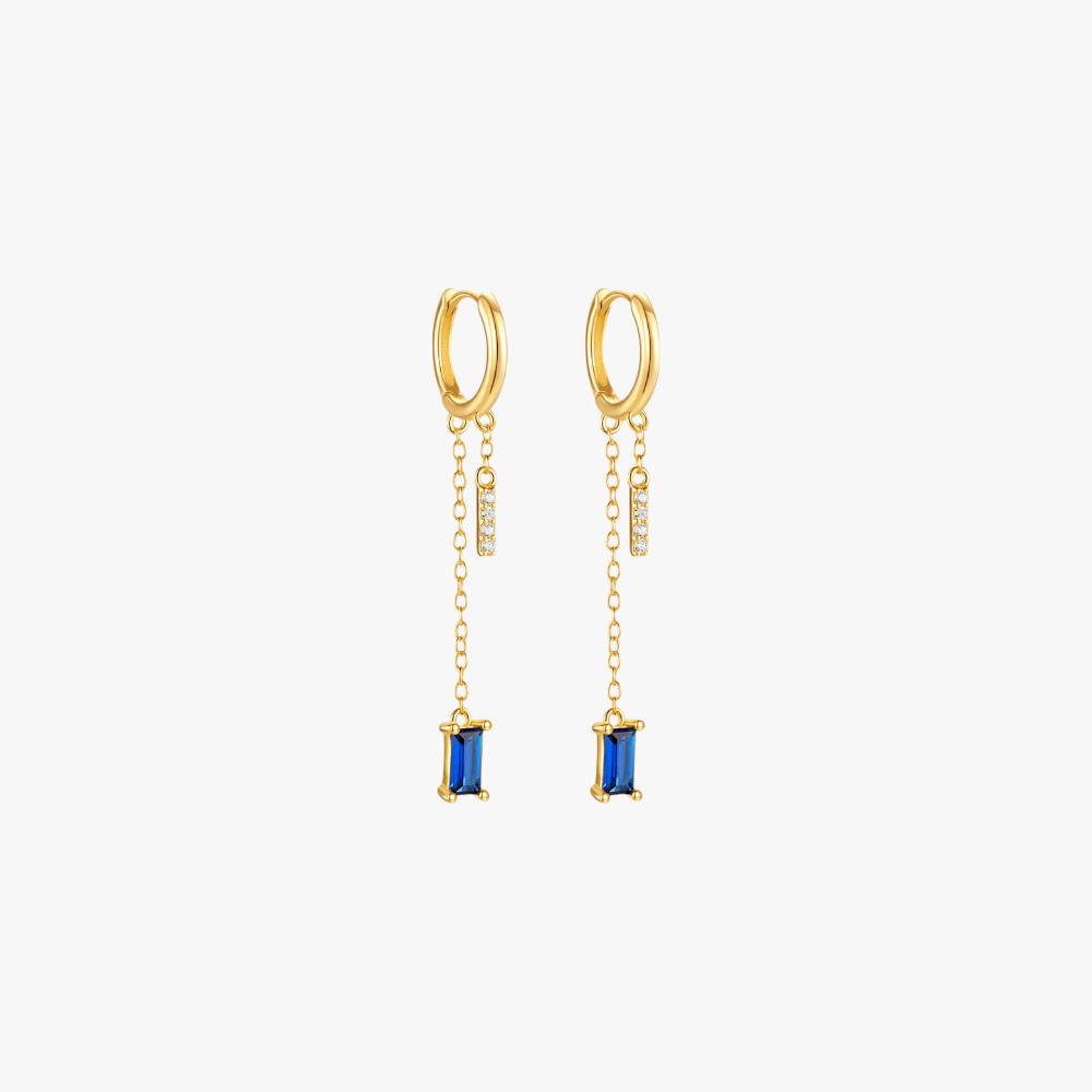 Gold drop earrings with blue gemstones, luxurious and trendy.