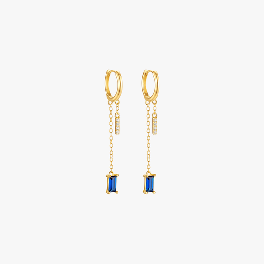 Gold drop earrings with blue gemstones, luxurious and trendy.