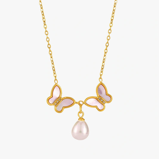 Close-up of the Butterfly Pendant Necklace featuring a pink butterfly design and a lustrous shell pearl, set on a delicate gold chain.