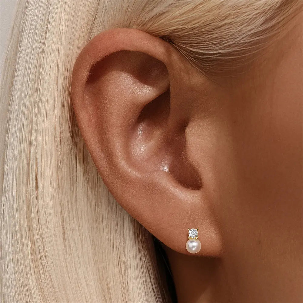 Elegant pearl and zirconia gold-plated stud earrings worn on a model for a sophisticated look.