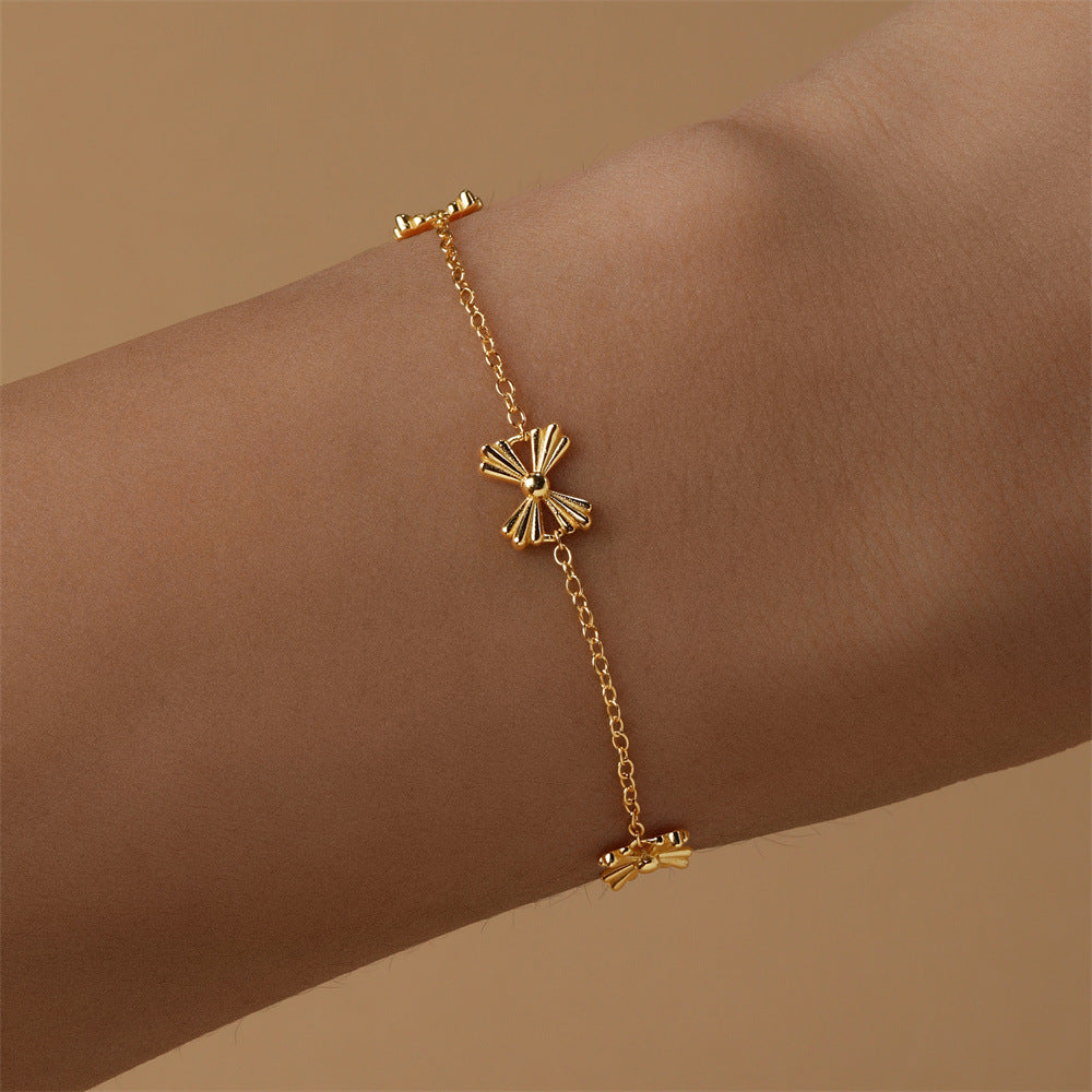 Dainty gold butterfly bracelet on wrist, crafted from 925 sterling silver with intricate bow details.