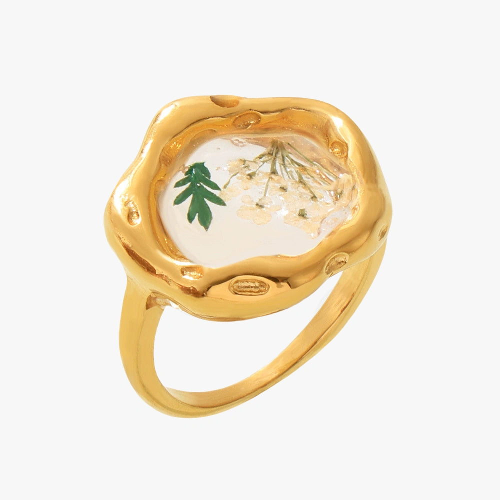  Close-up of a gold floral resin ring featuring a detailed design of dried flowers with oil drip accent.