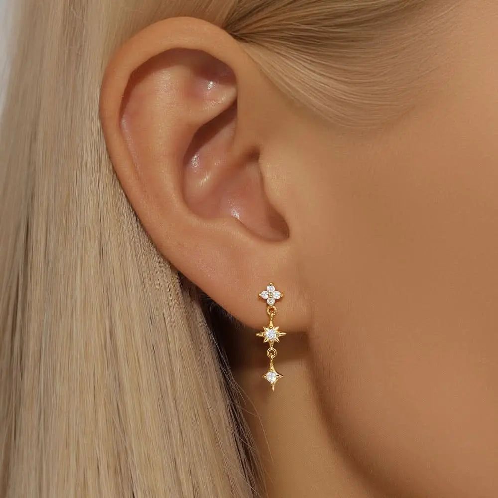 Floral diamond drop earrings in gold, beautifully displayed on the model for a delicate touch of luxury.