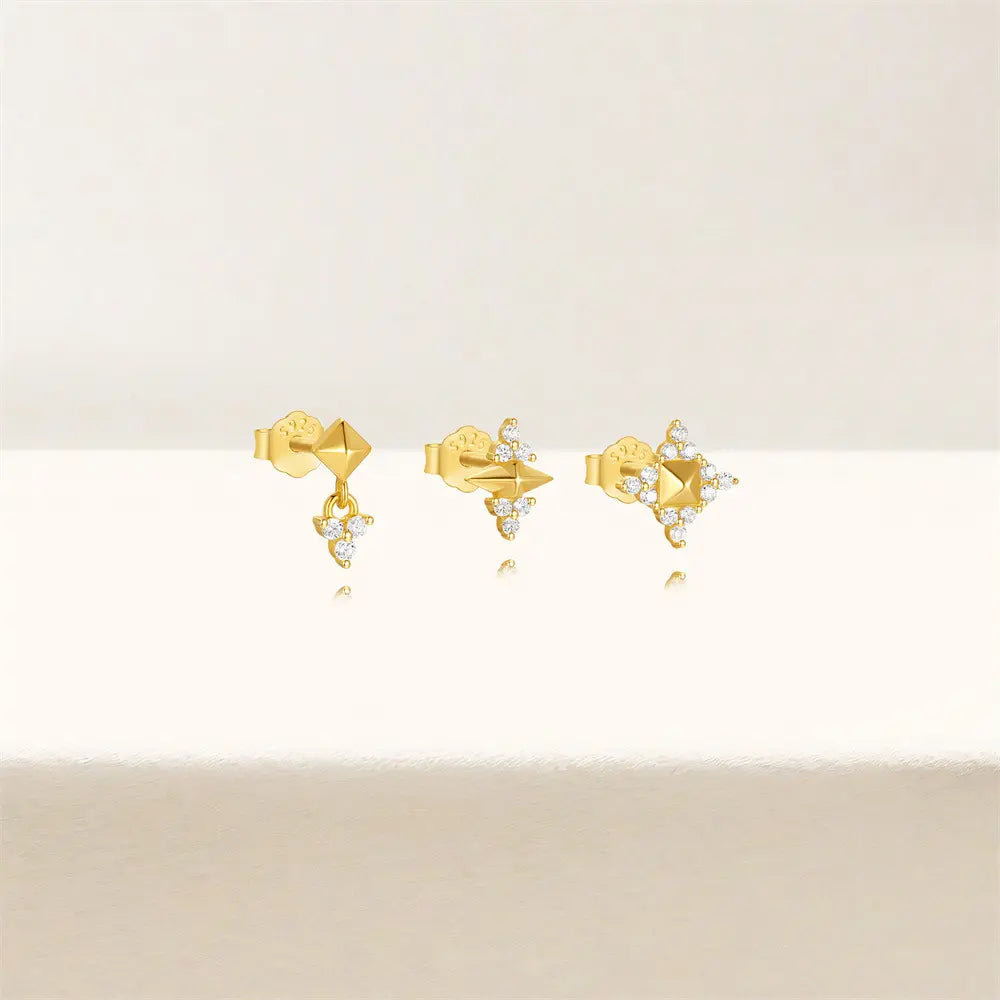 Set of three gold geometric stud earrings with crystal details, displayed on a neutral background for an elegant presentation.