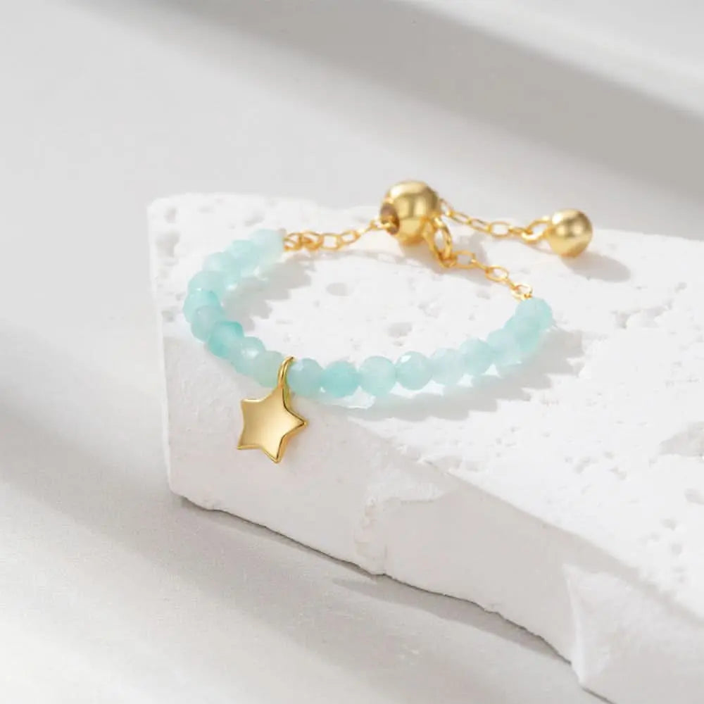 Gold and aquamarine star beaded ring, an adjustable piece with a simple and elegant design.