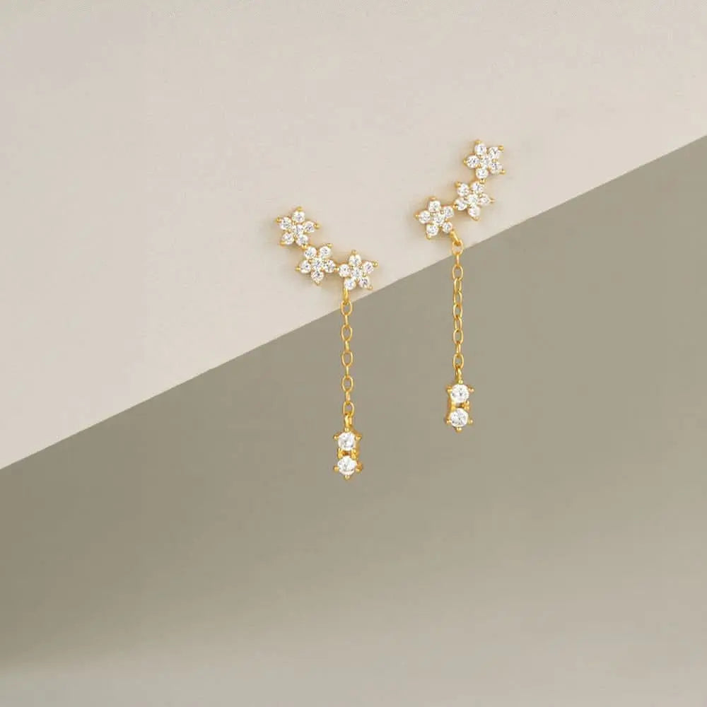 Exquisite gold chain earrings with diamond stars and floral accents, perfect for women.