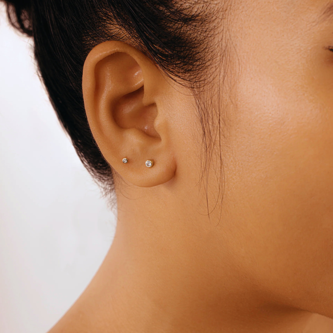 Classic diamond stud earring in 14K gold, styled on an ear for a timeless and sophisticated look.