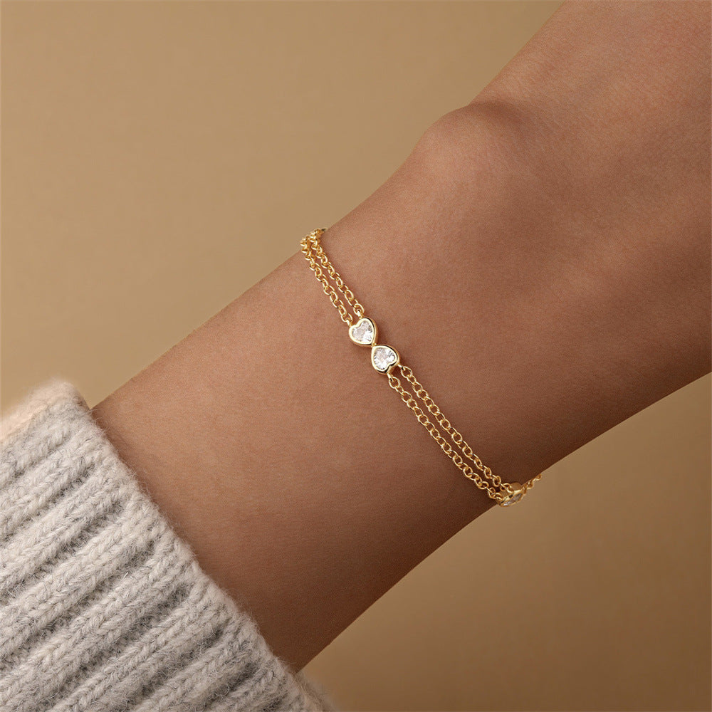 A gold-plated heart bracelet in S925 sterling silver elegantly worn on the wrist, showcasing its delicate charm.