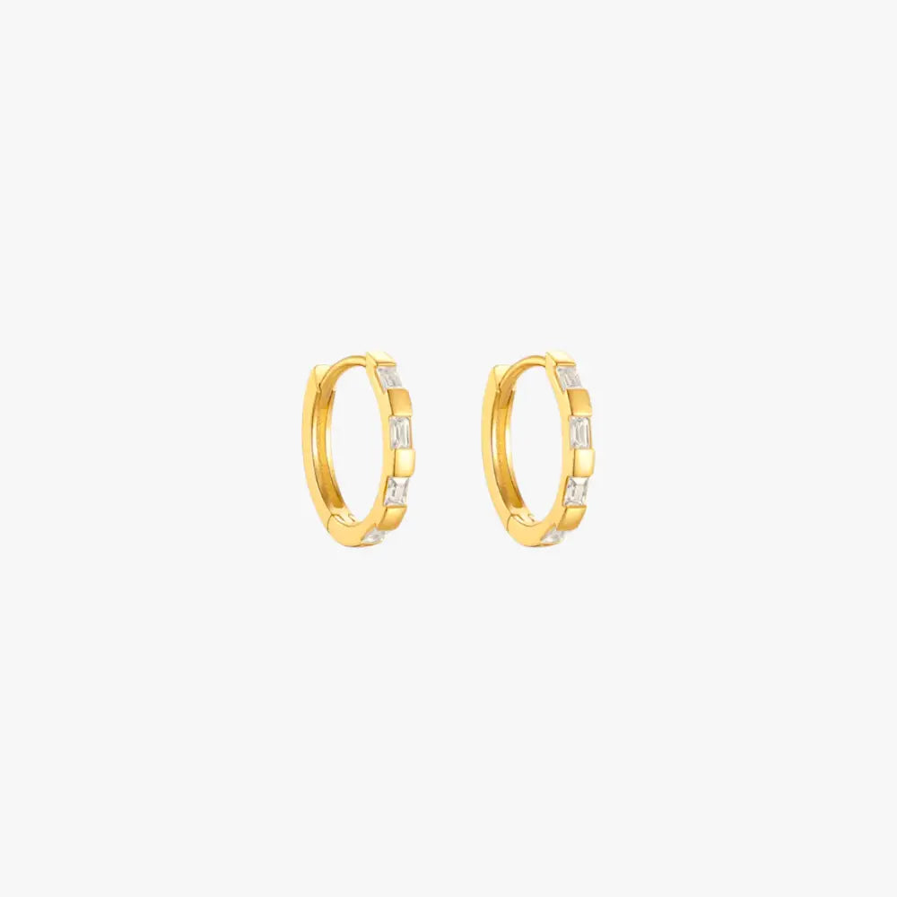 Gold huggie earrings featuring baguette diamonds, ideal for adding a touch of luxury.