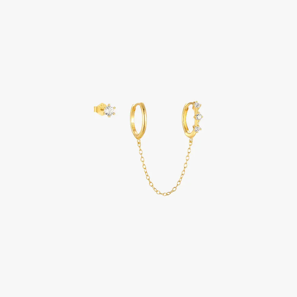 Gold huggie earrings with diamond star and chain, minimalist and trendy design.