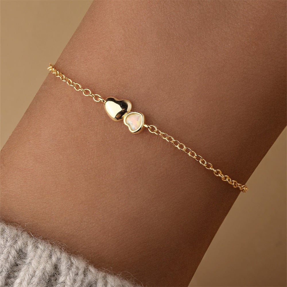 Delicate gold opal heart bracelet worn on wrist, lightweight and stylish everyday jewelry.